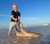 boy poses with small shark