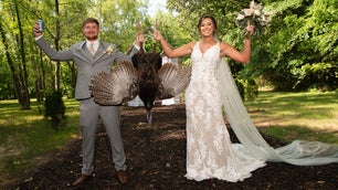 bride and groom hold dead turkey
