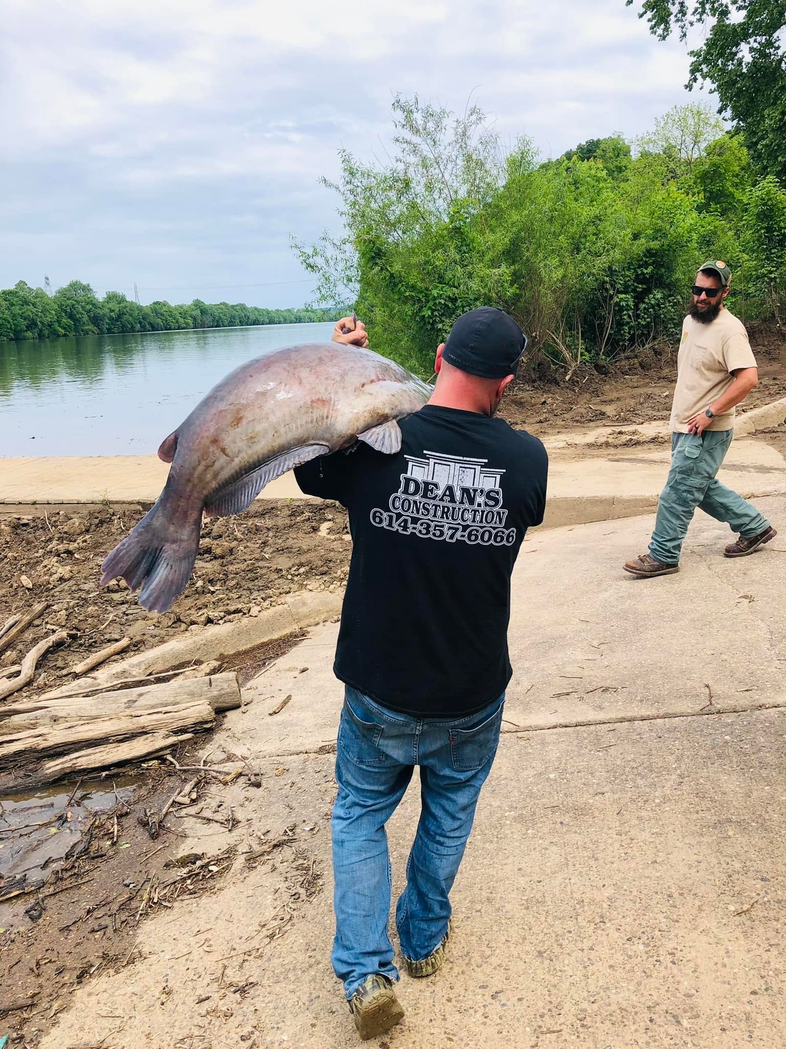 man slings large catfish over shoulder