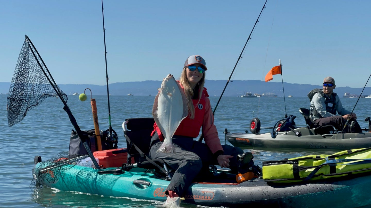 kayak angler holds white halibut from kayak