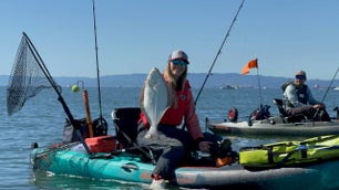 kayak angler holds white halibut from kayak