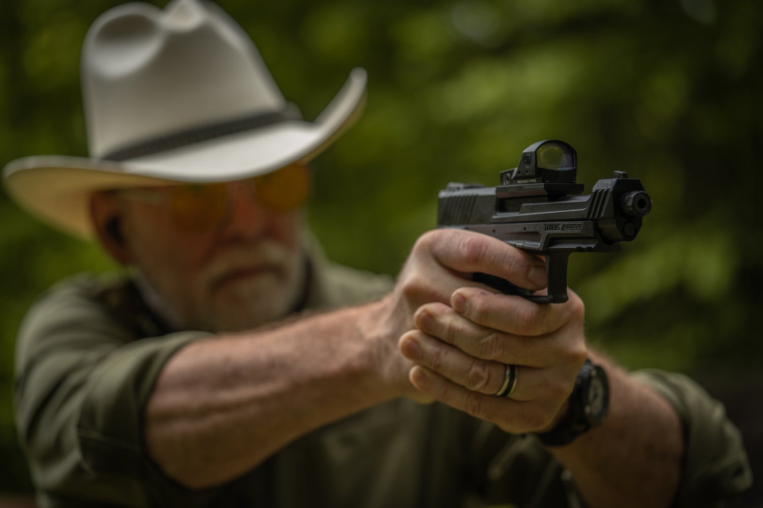 The man with the cowboy hat who shoots a semi-automatic pistol.