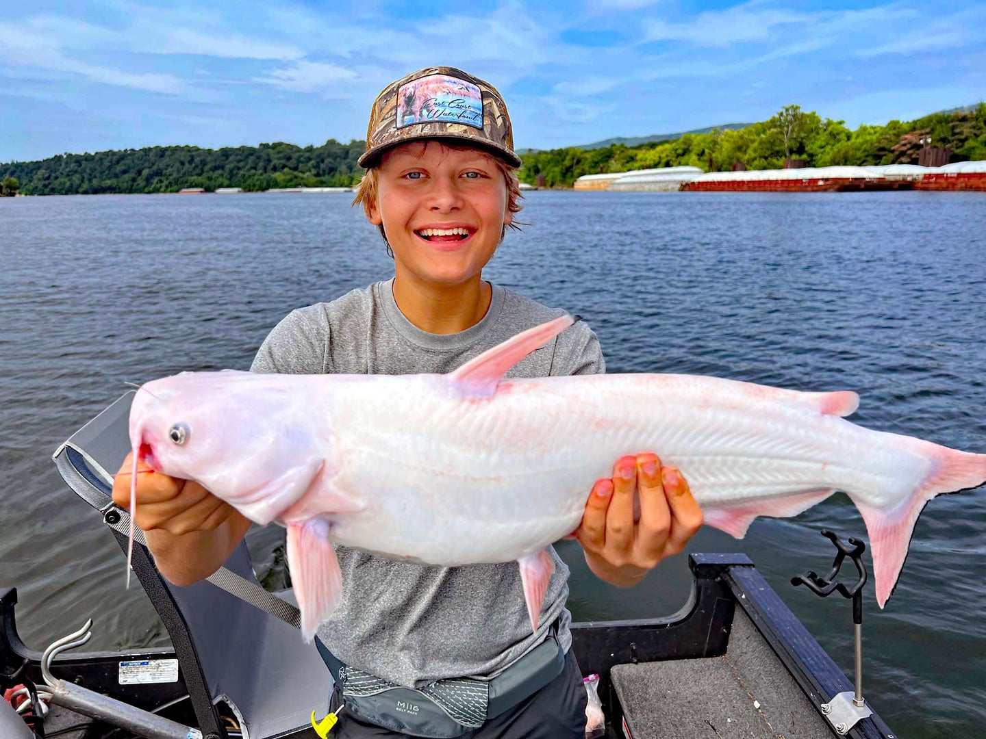 boy smiles with white catfish