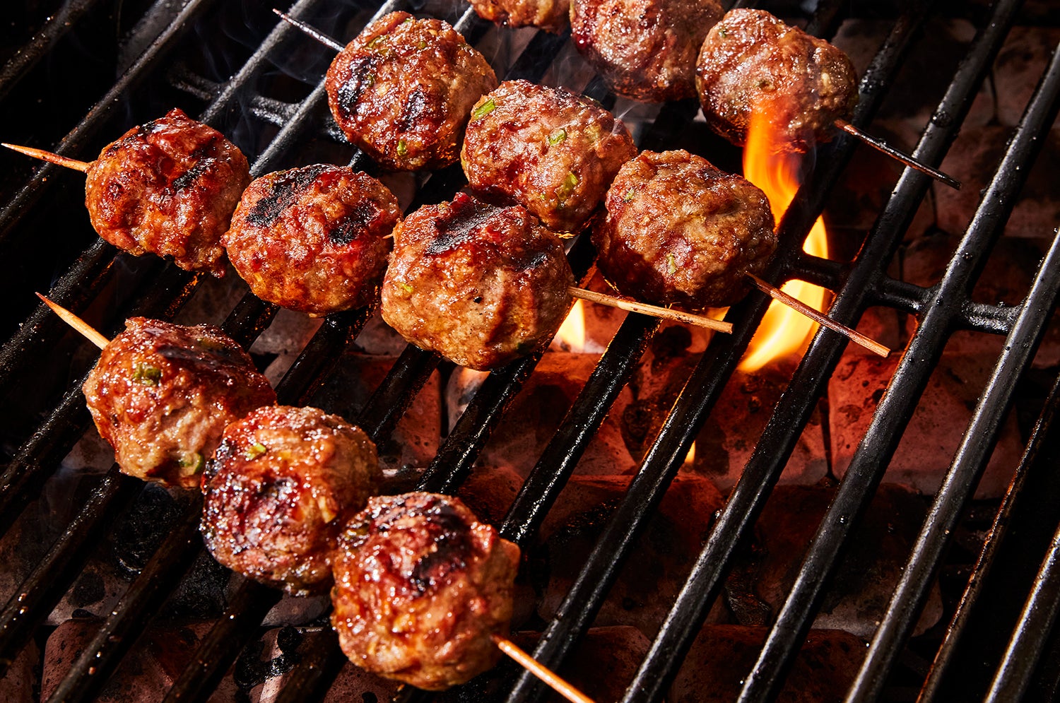barbecuing meatballs on skewers