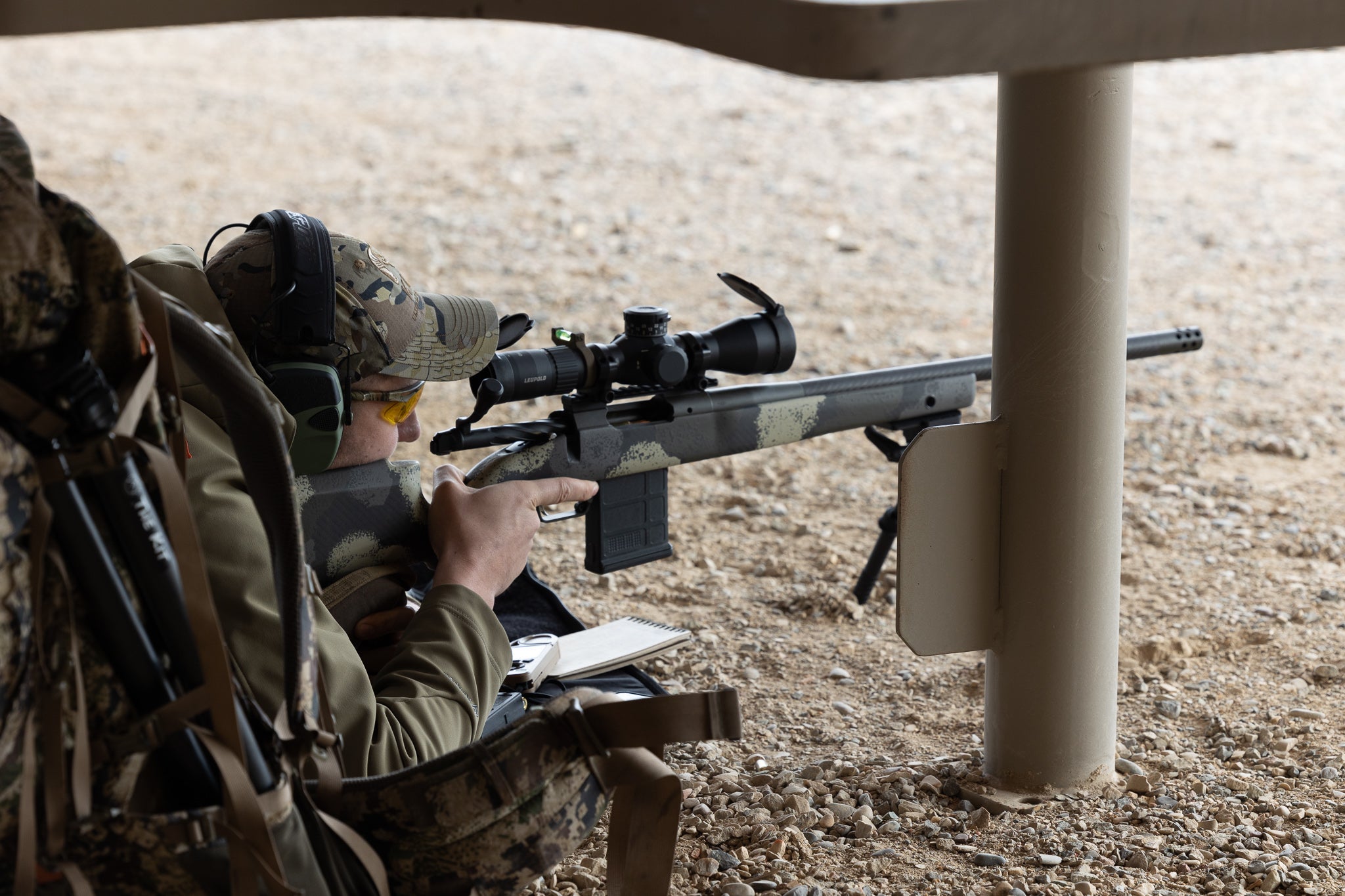 A man shooting a rifle in the prone position.