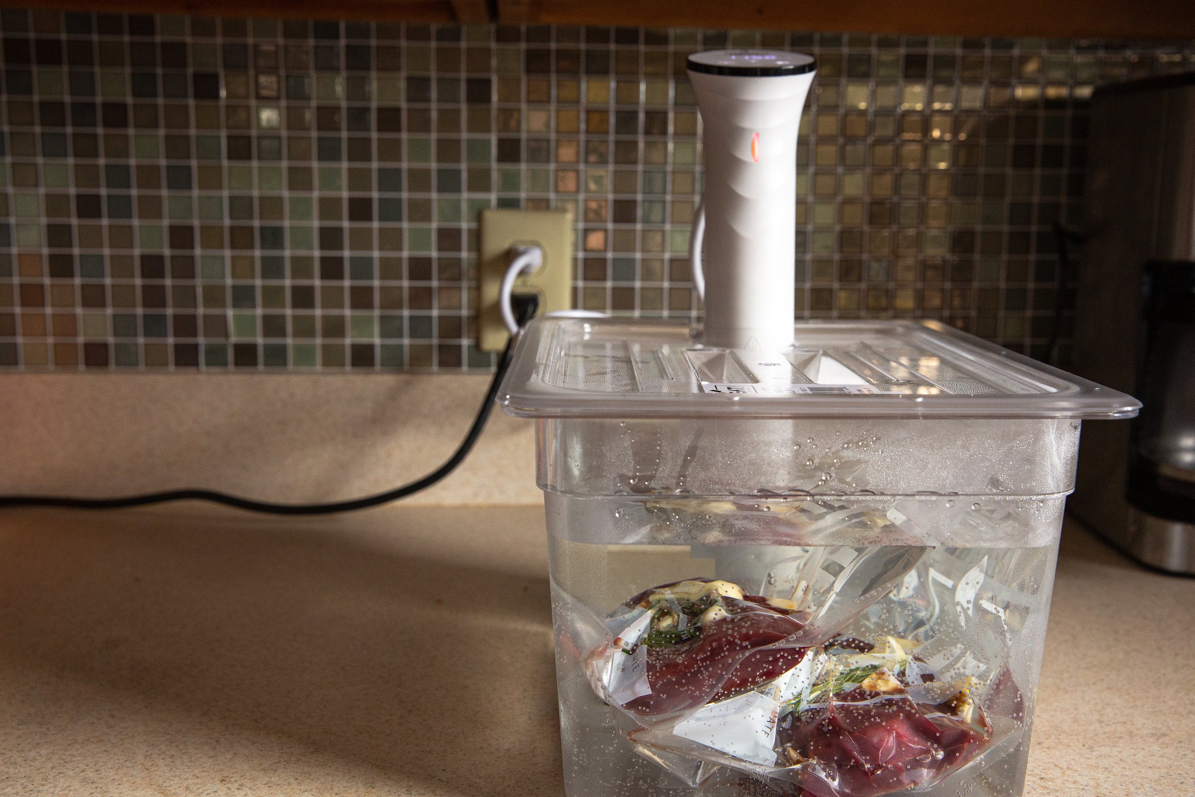 sous vide cooker with vension in a hot water bath.