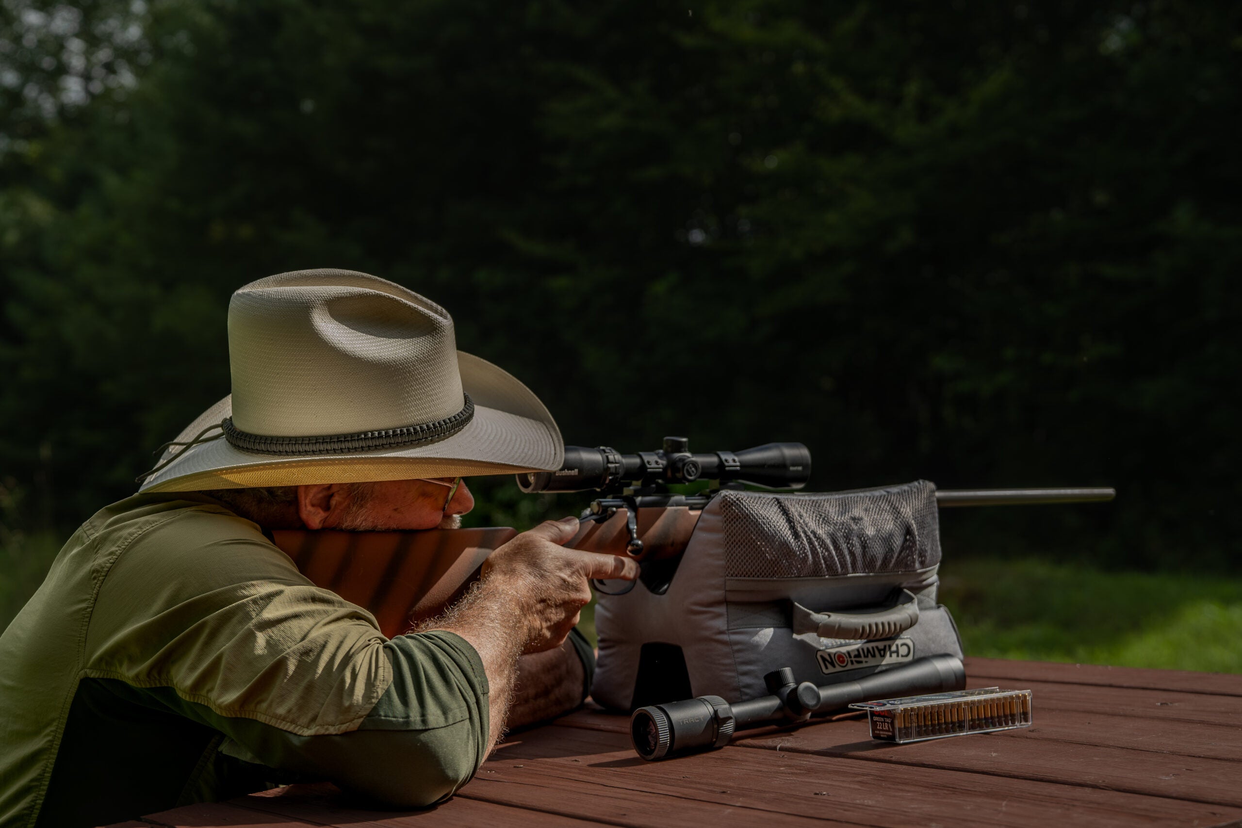 Man shooting rimfire rifle on a bench. 