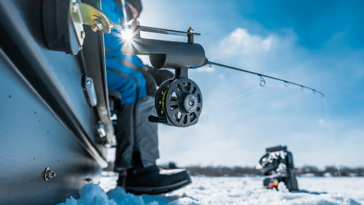 Angler using Clam ice fishing reel in boat