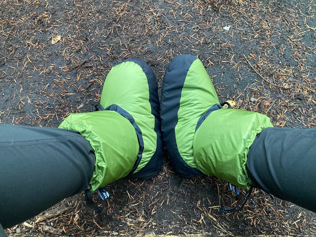 Camper wearing green Feathered Friends Down Booties