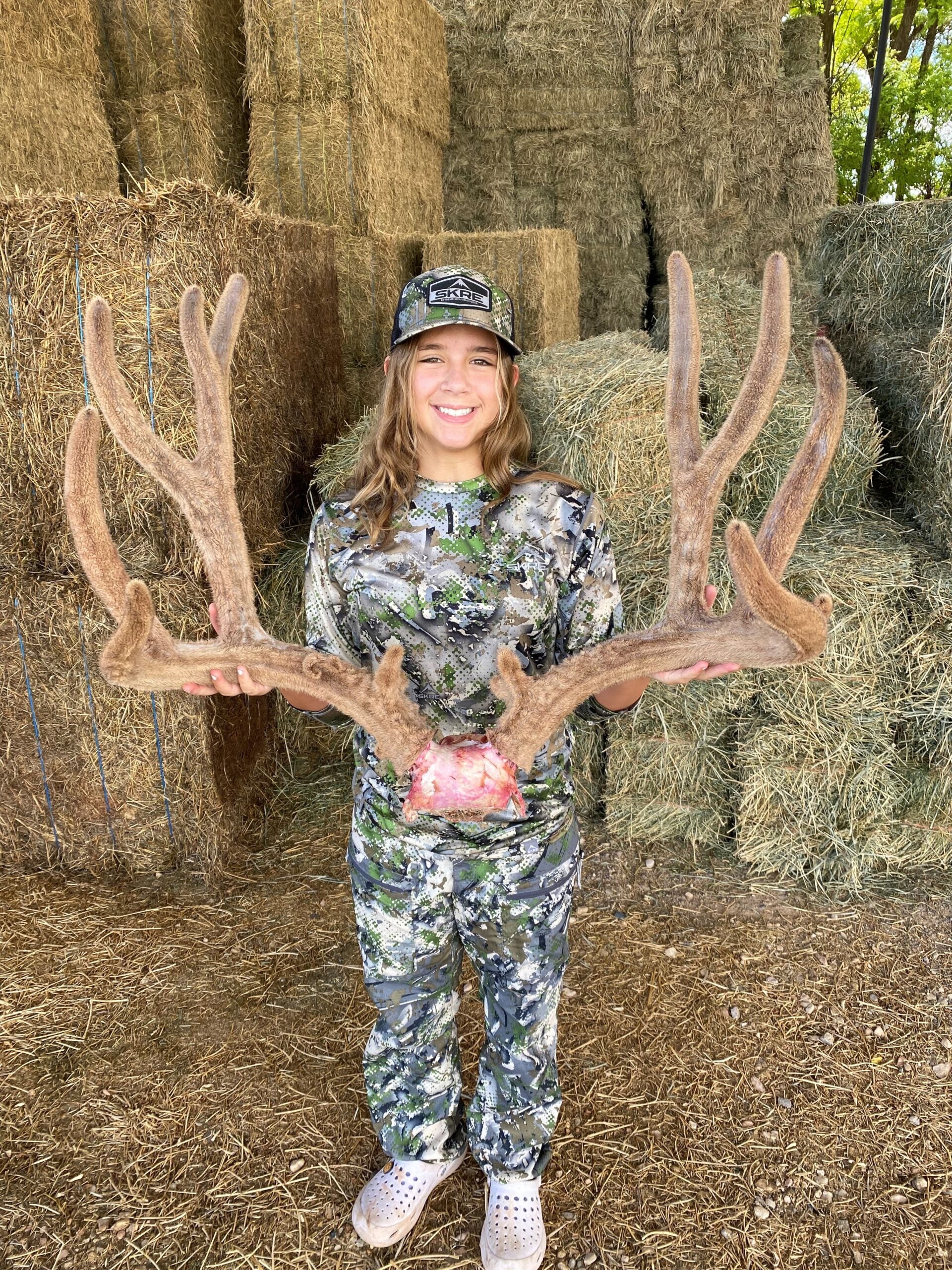 photo of a girl with a rack of mule deer
