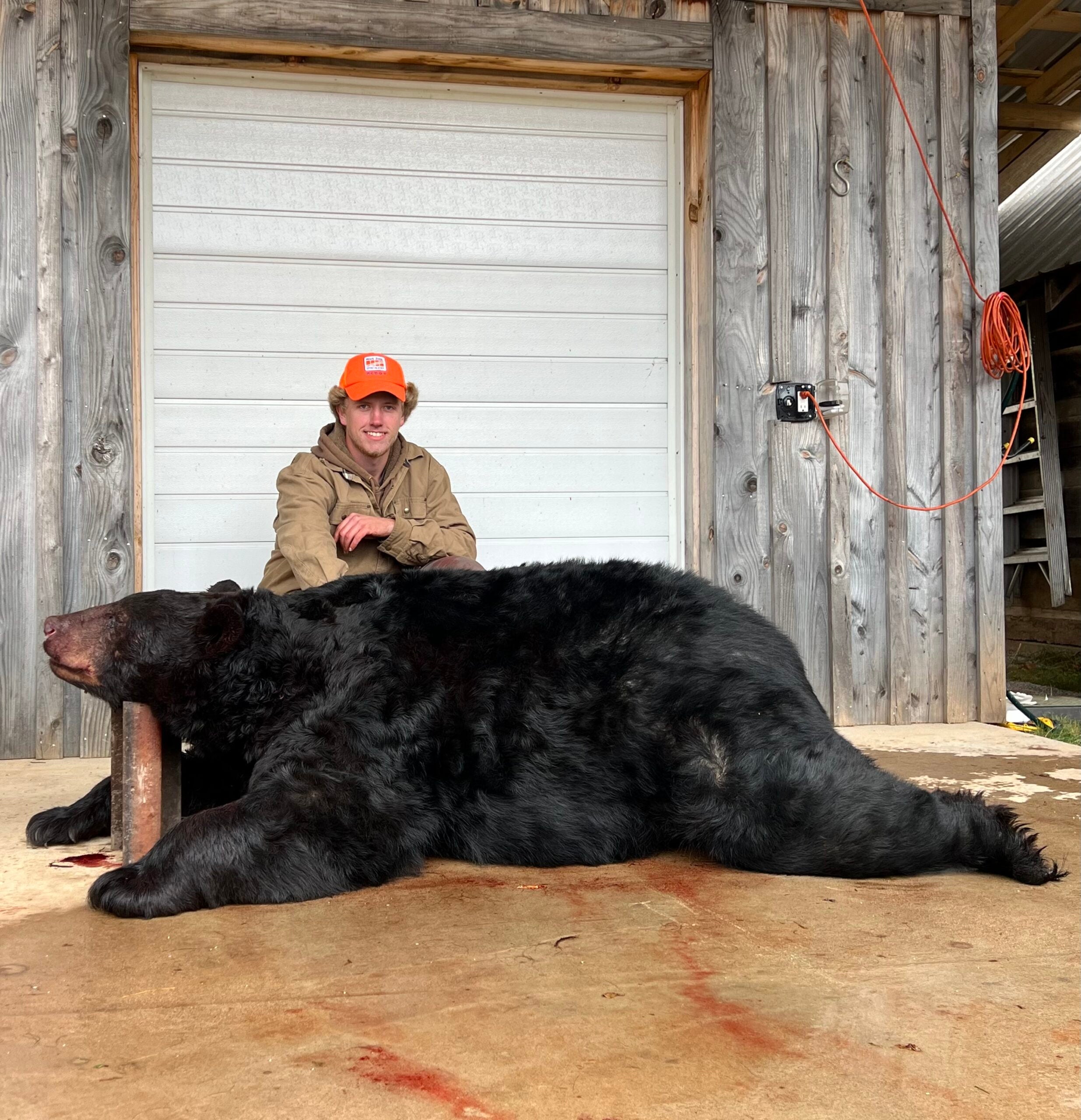 the hunter poses with the big black bear
