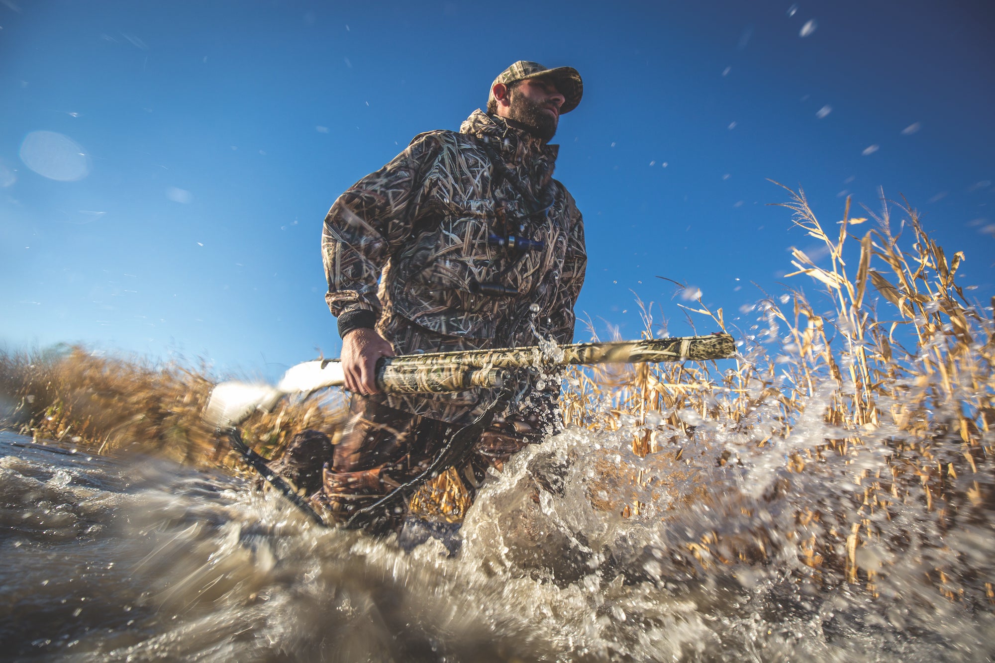 hunter carrying a mossberg 500 in a duck marsh.