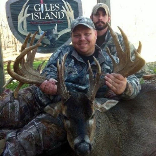 two hunters with a dead whitetail deer