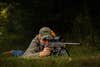 Man in the prone position shooting a rifle.