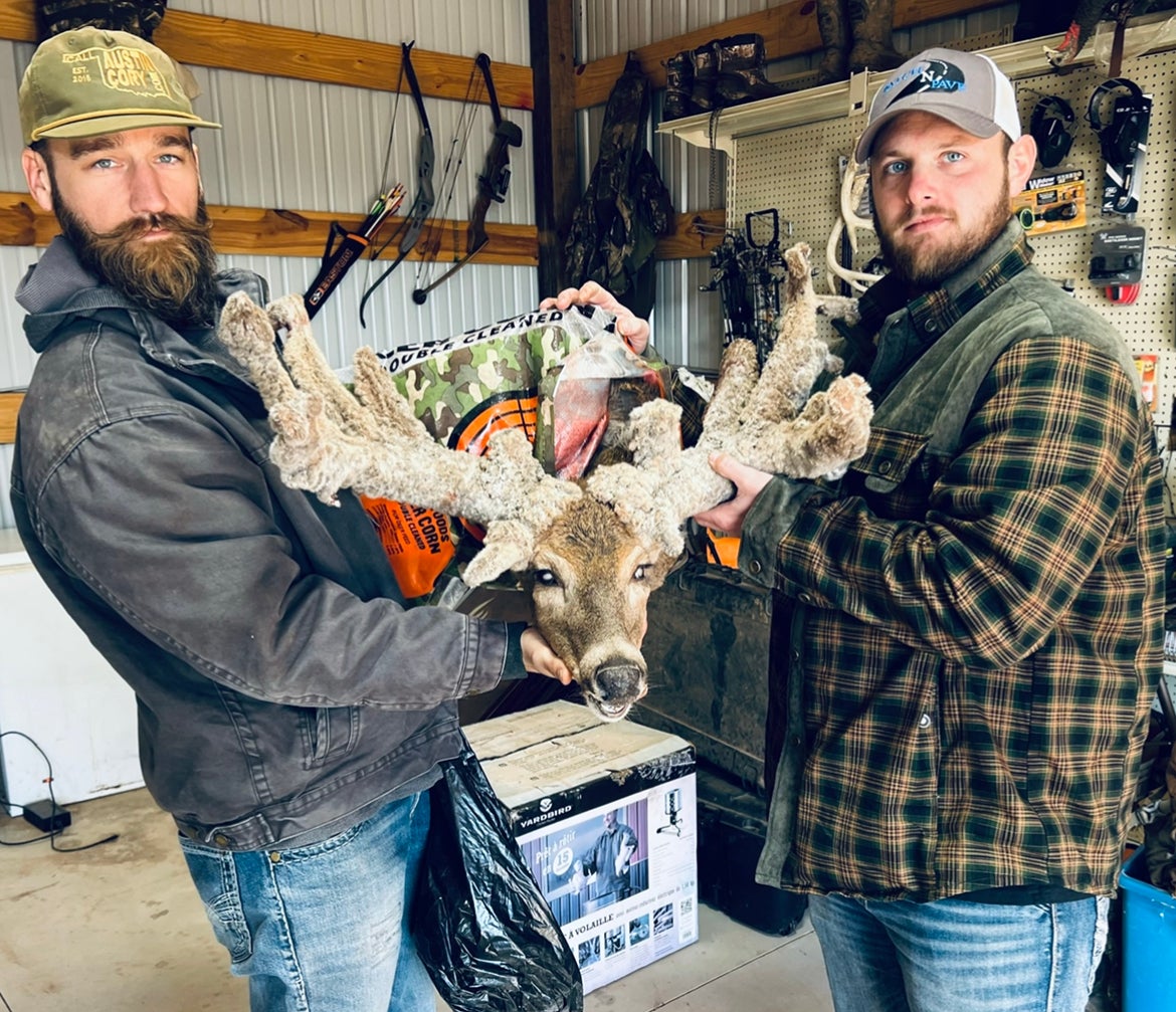 Two hunters with a dead cactus buck.