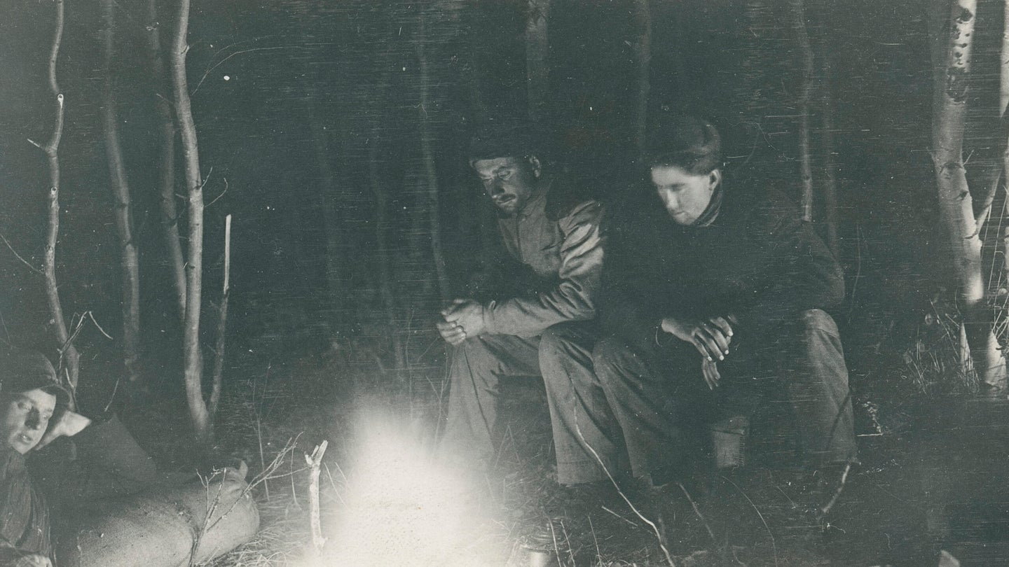 three men around campfire