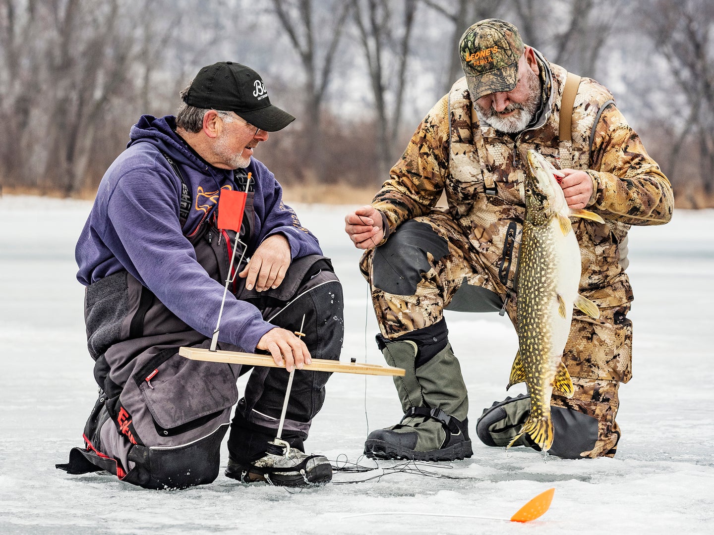 two ice fishermen with pike
