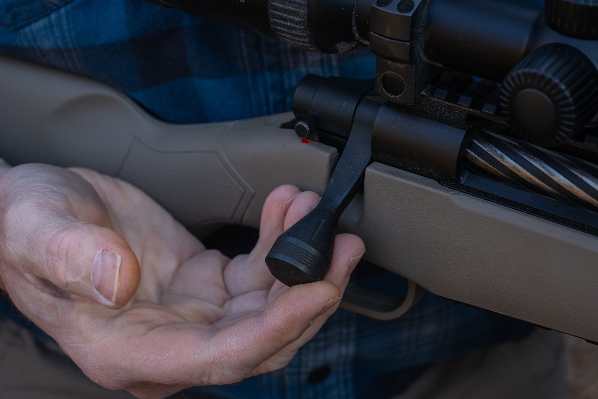 Hunter showing the bolt handle on a Mossberg Patriot Predator Rifle in 7mm PRC.