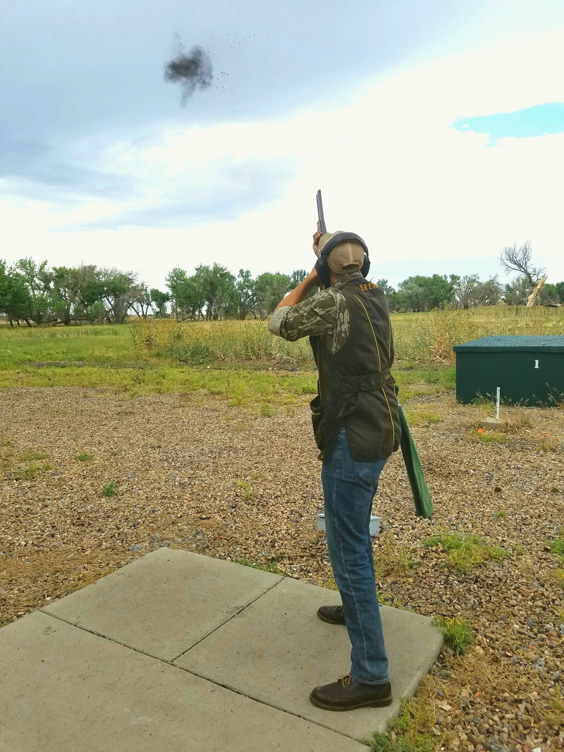 trap vs skeet: a shotgun shooter shooting a clay in mid air