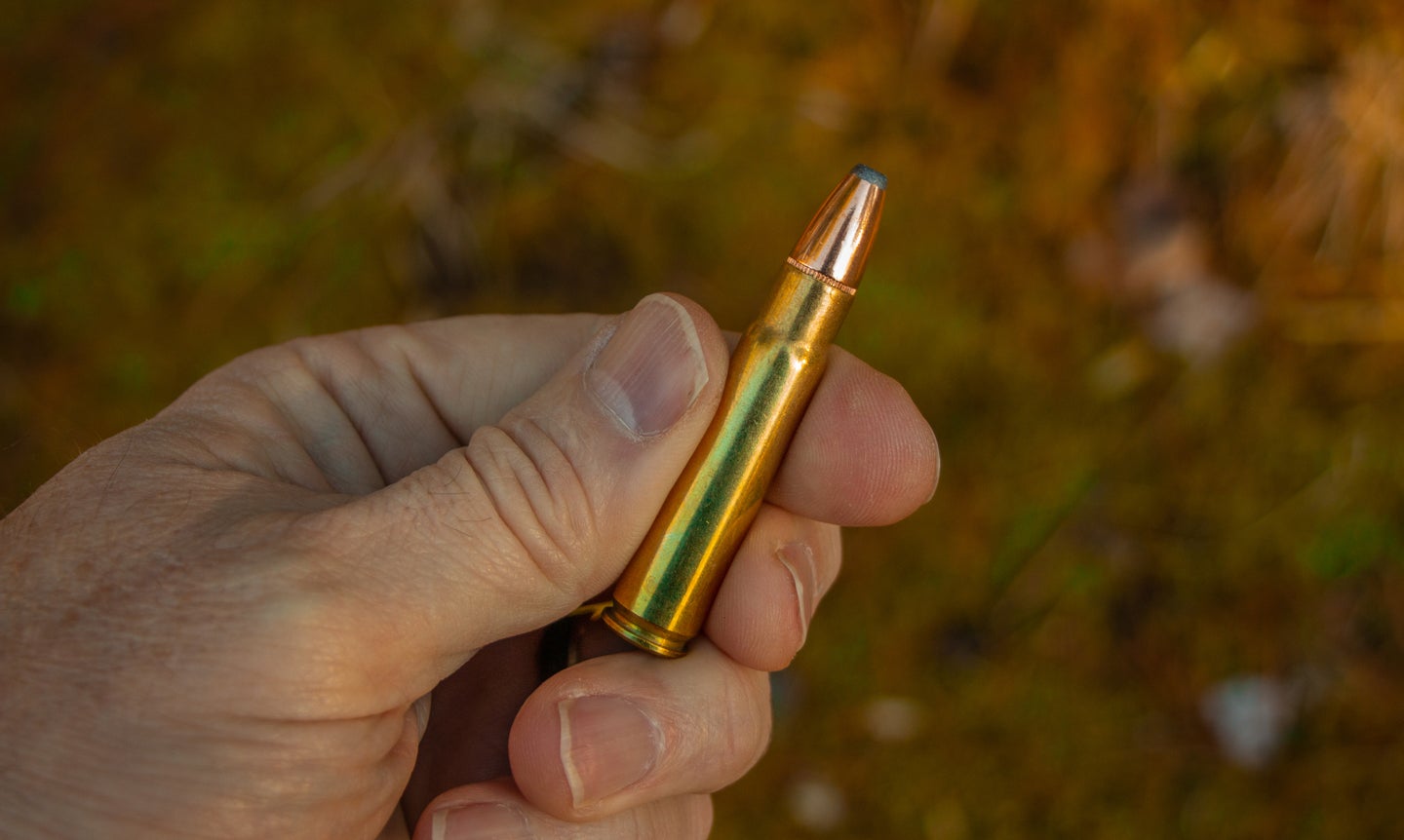 Hand holding a 35 Remington cartridge.