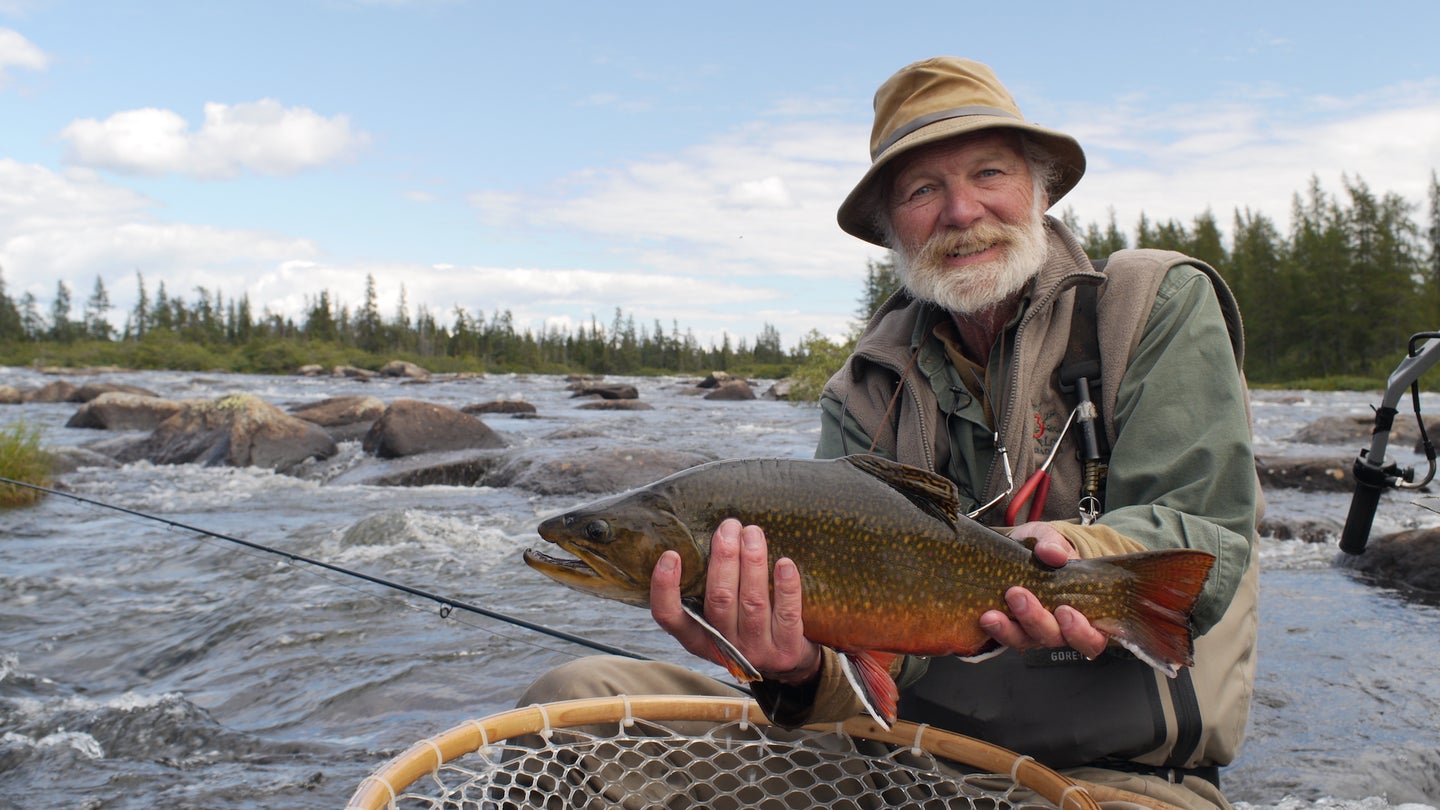 Author John Gierach holding a trout.