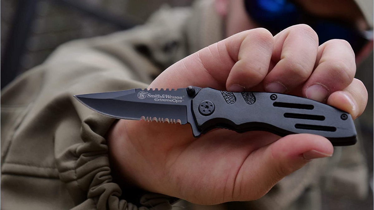 Man holding Smith & Wesson Extreme Ops Knife with Serrated Blade