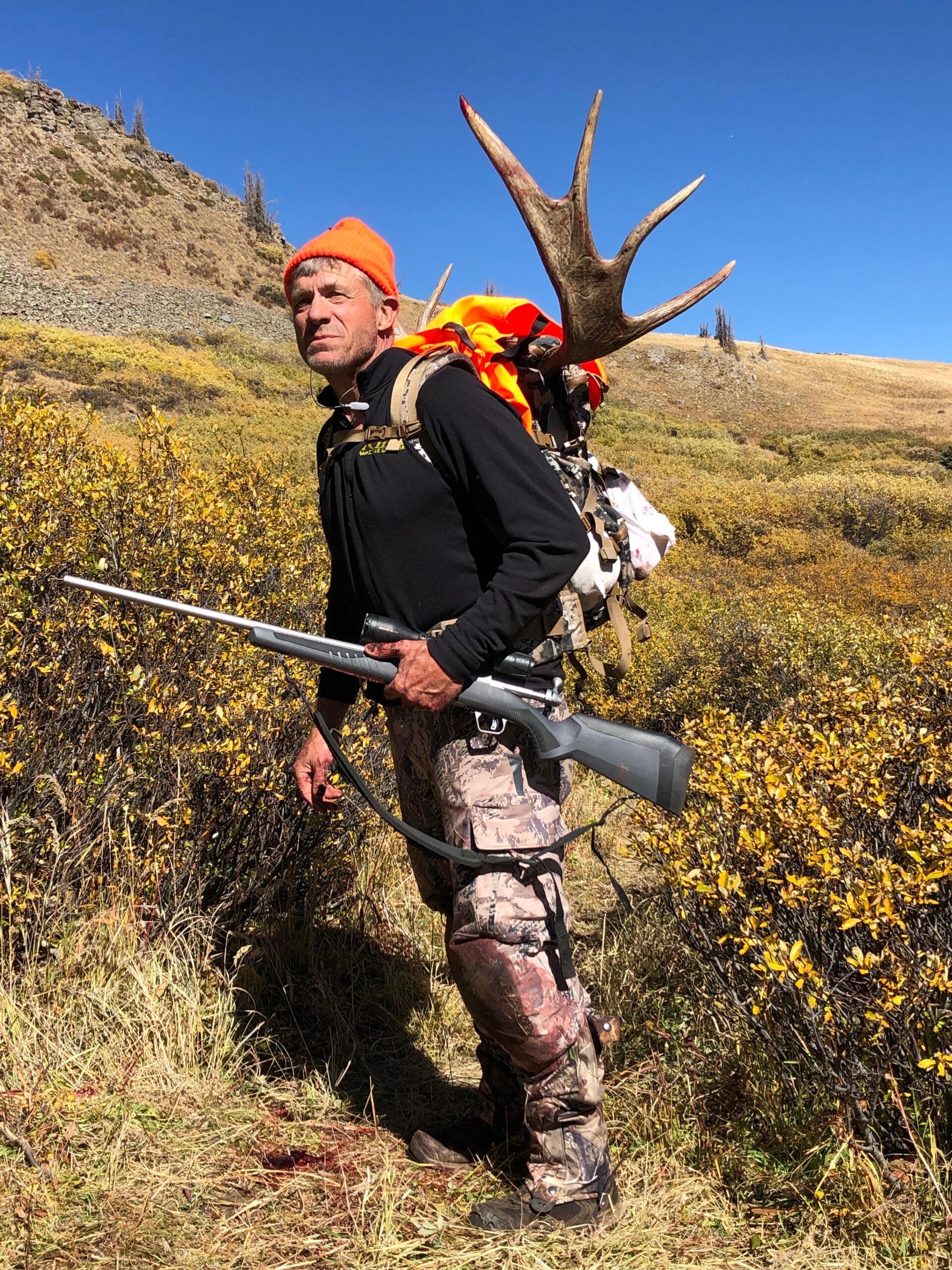 Moose hunting: man walking with a backpack full of moose meat.