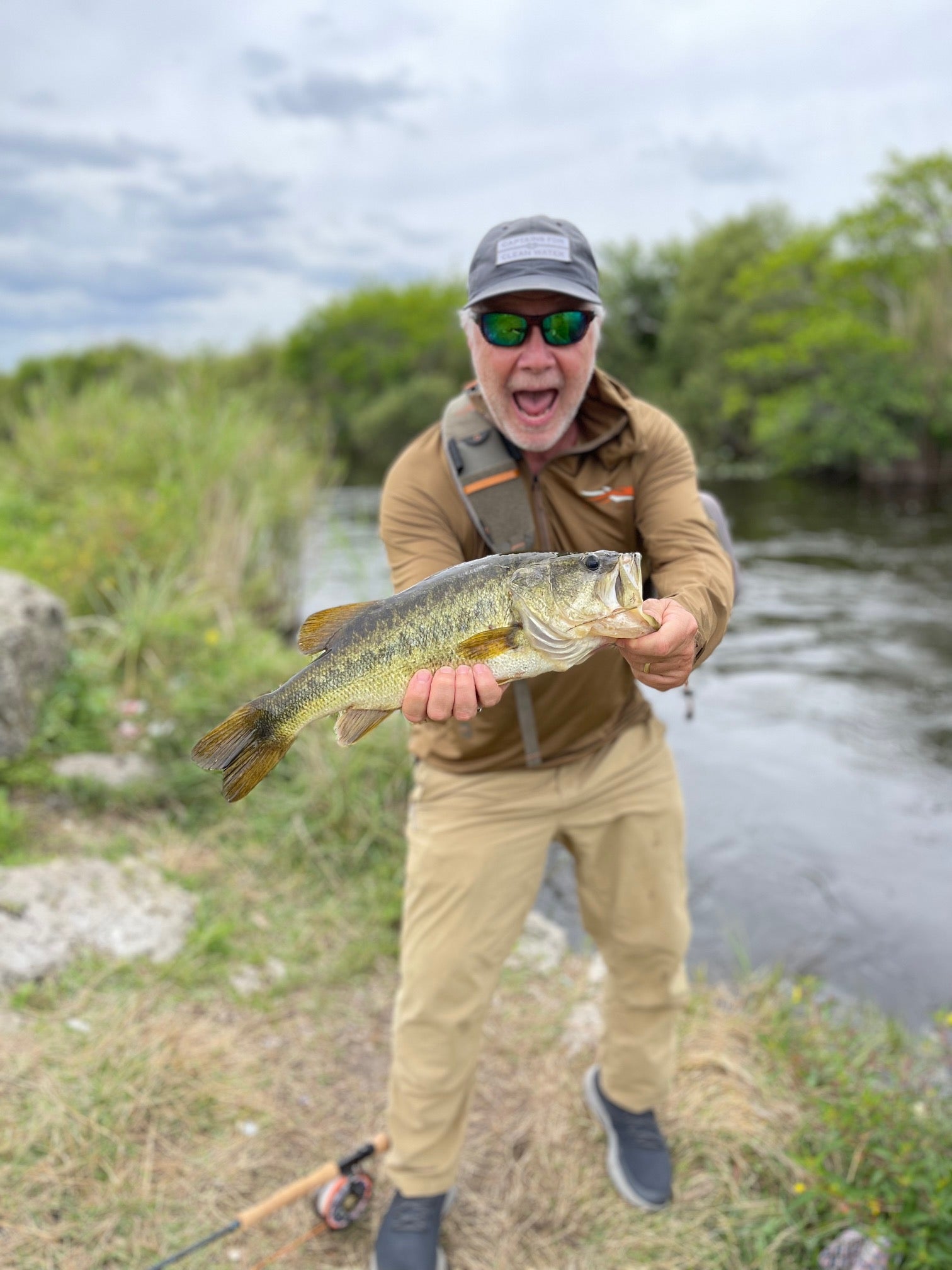 fly fisherman with a largemouth bass