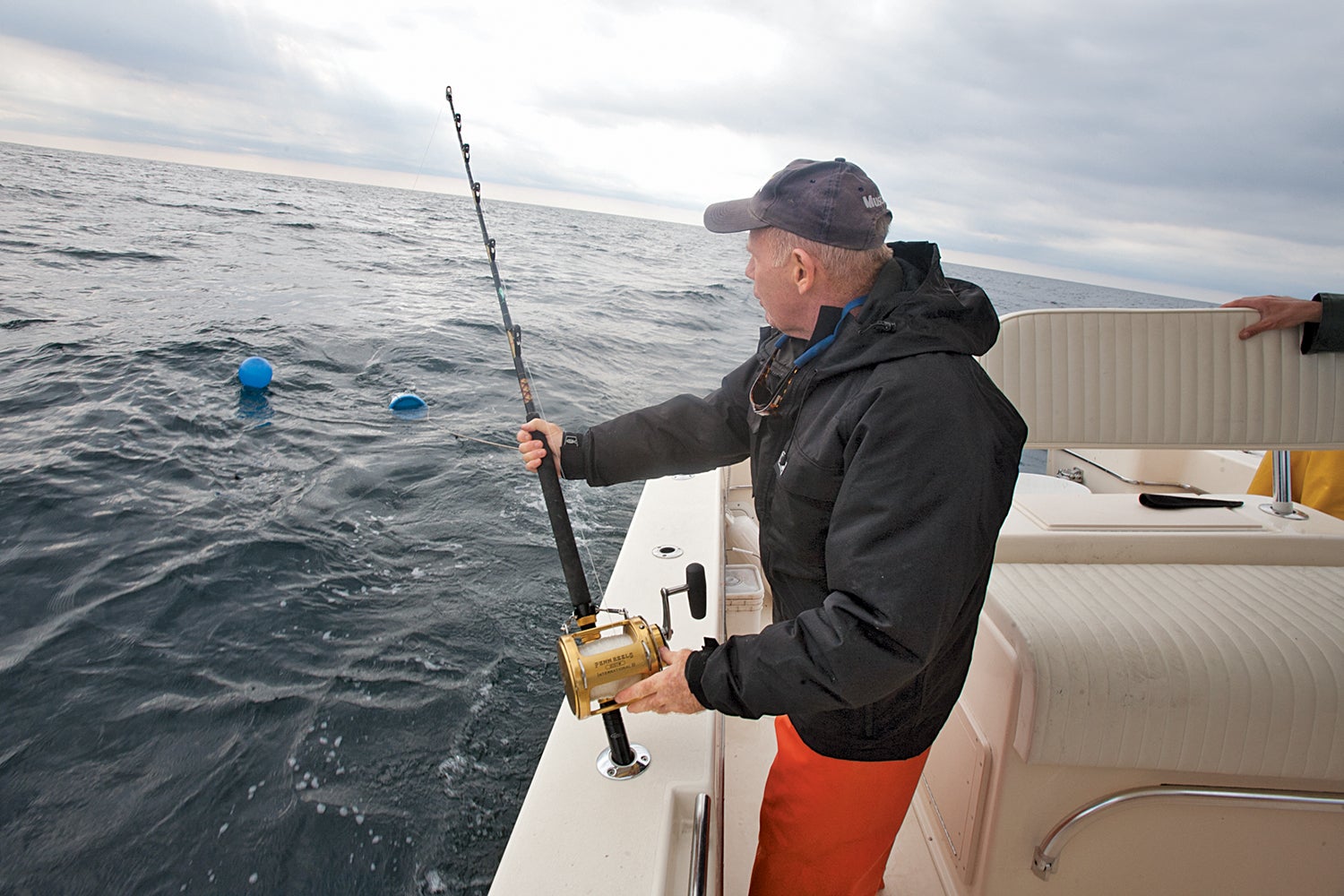 Angler lets bait buckets out of the back of the fishing boat.