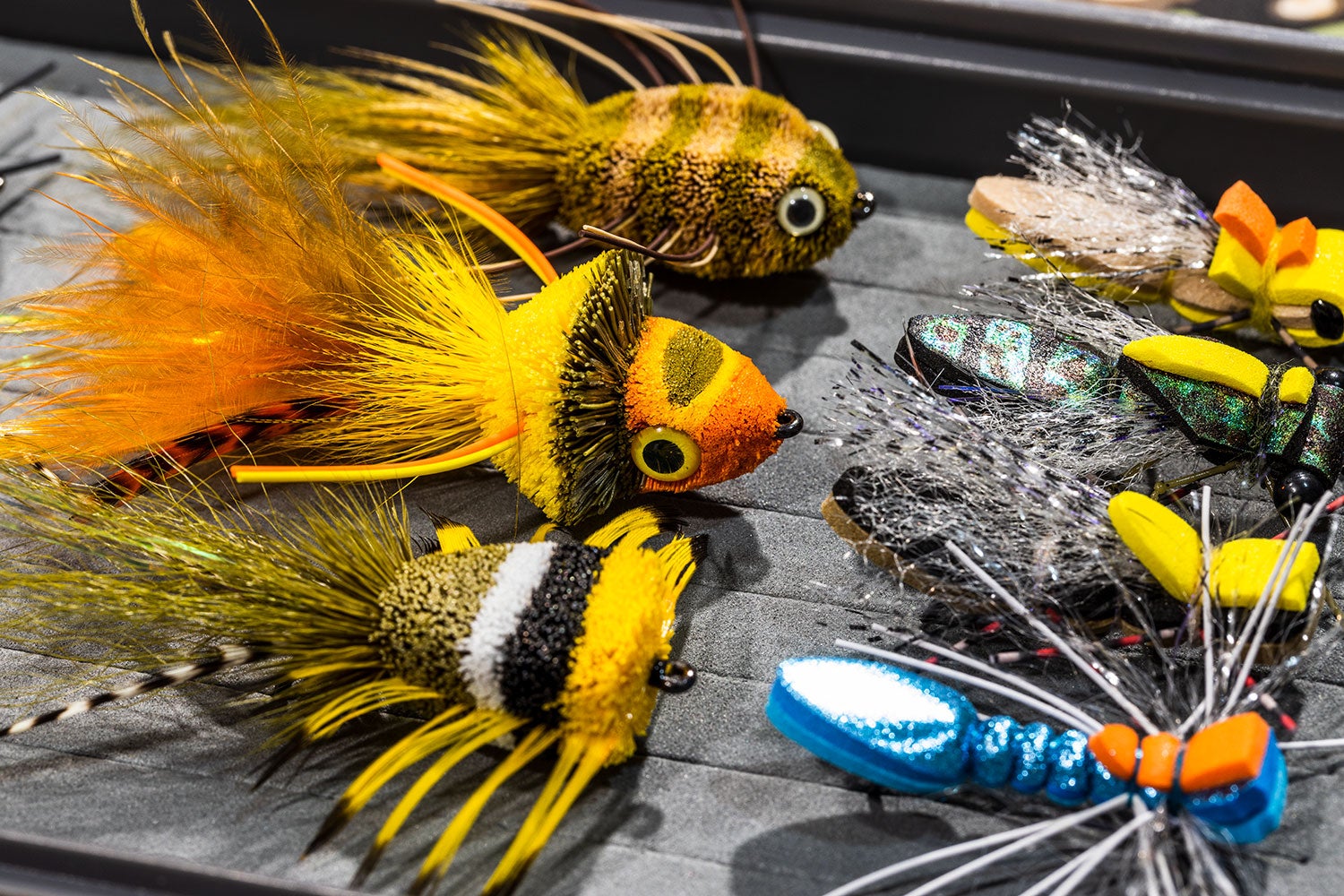 Colorful smallmouth bass flies are displayed in a fly box
