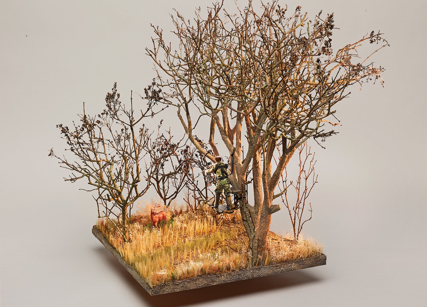 floating diorama of hunter in treestand and deer on ground