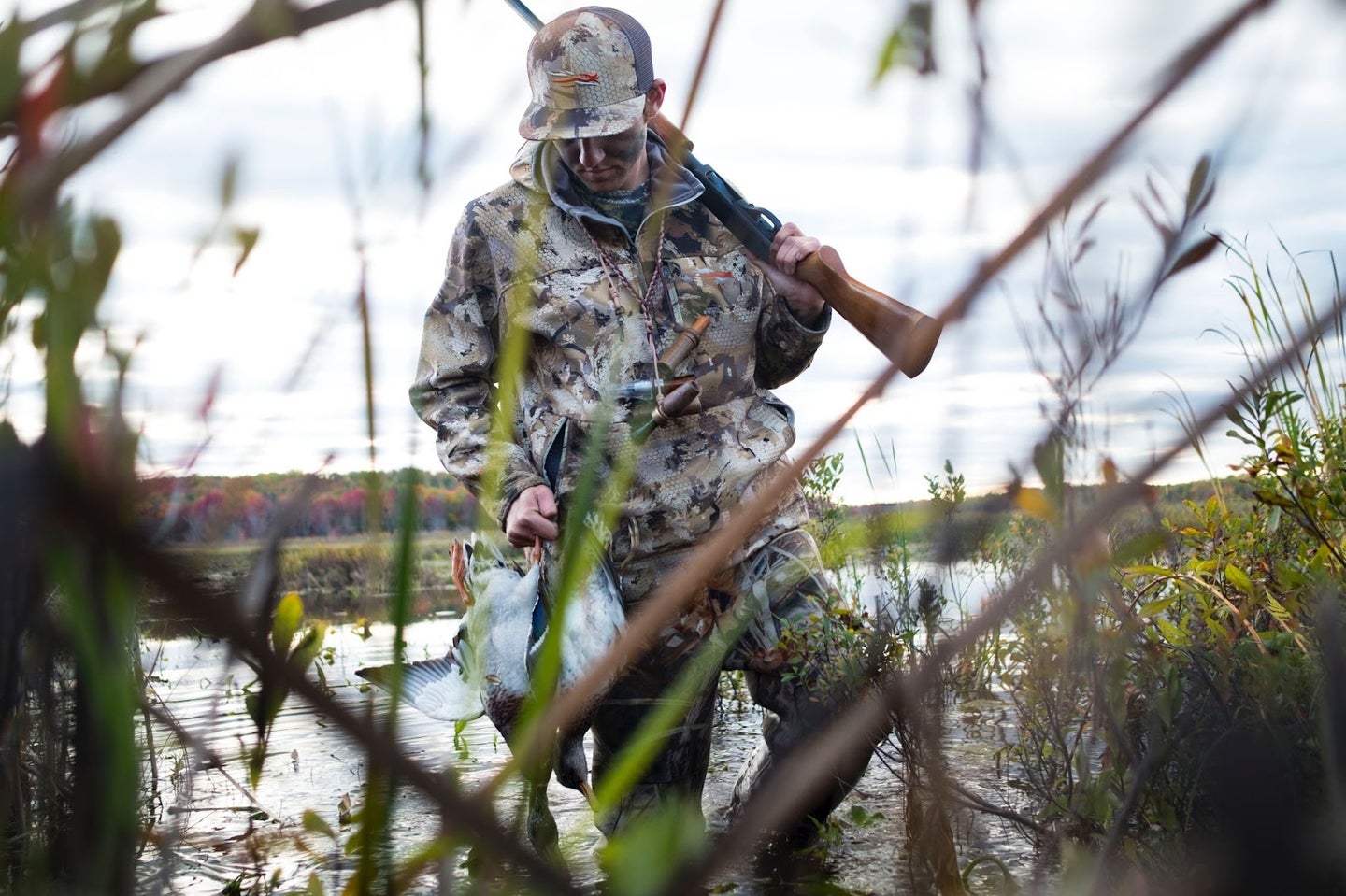 Hunter wearing Sitka duck hunting jacket, pants, and hat in the marsh