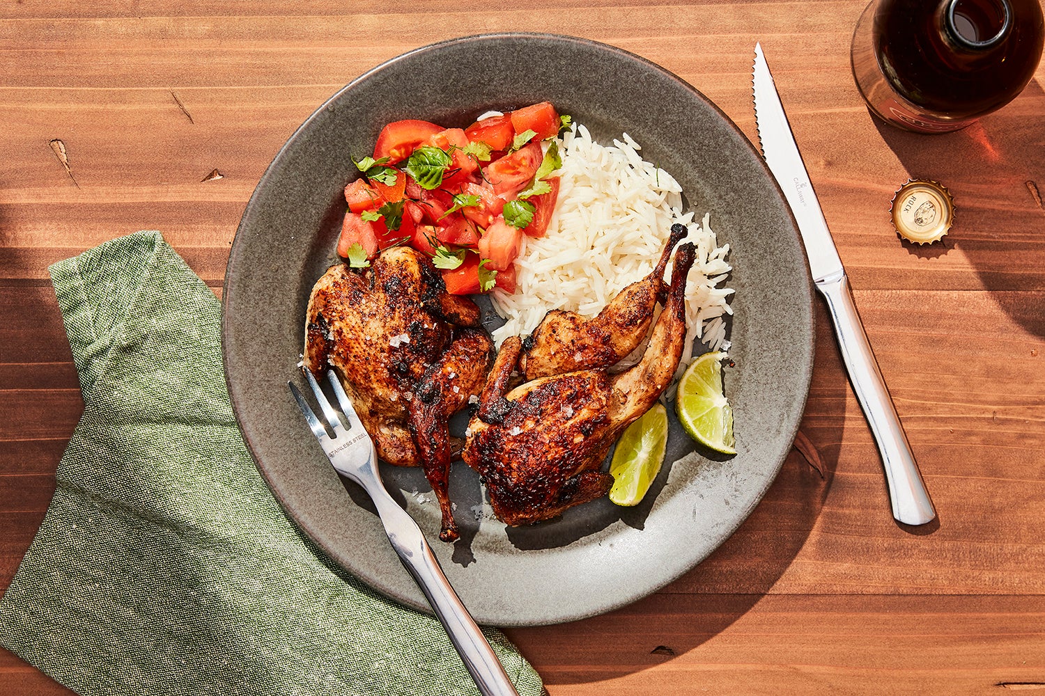 plate with cooked quail, tomato salad, and rice