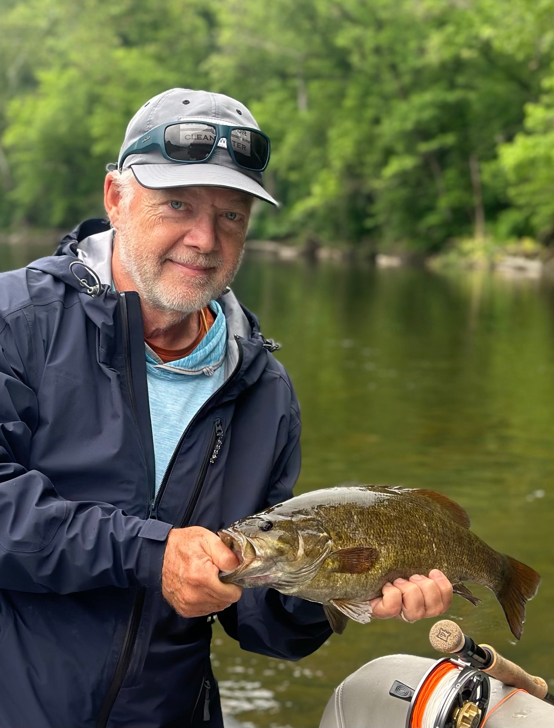 fly fisherman holds a smallmouth bass