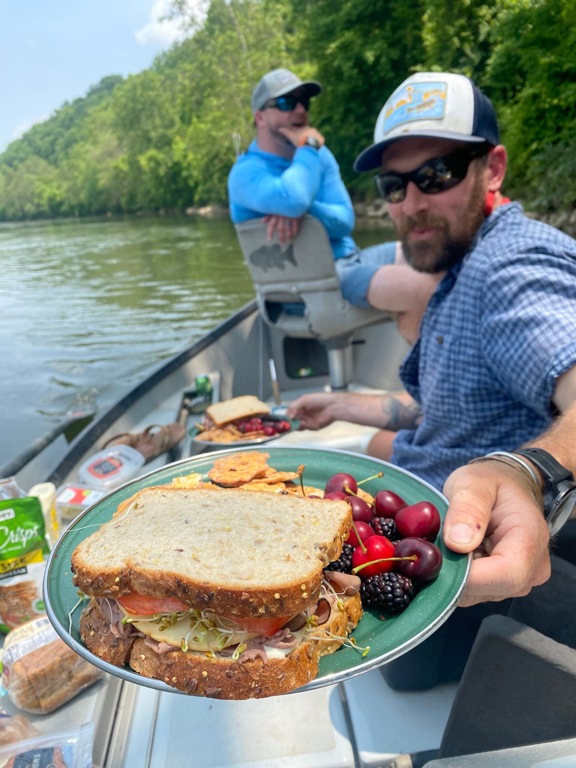 fishing guide serves a plate of food on drift boat