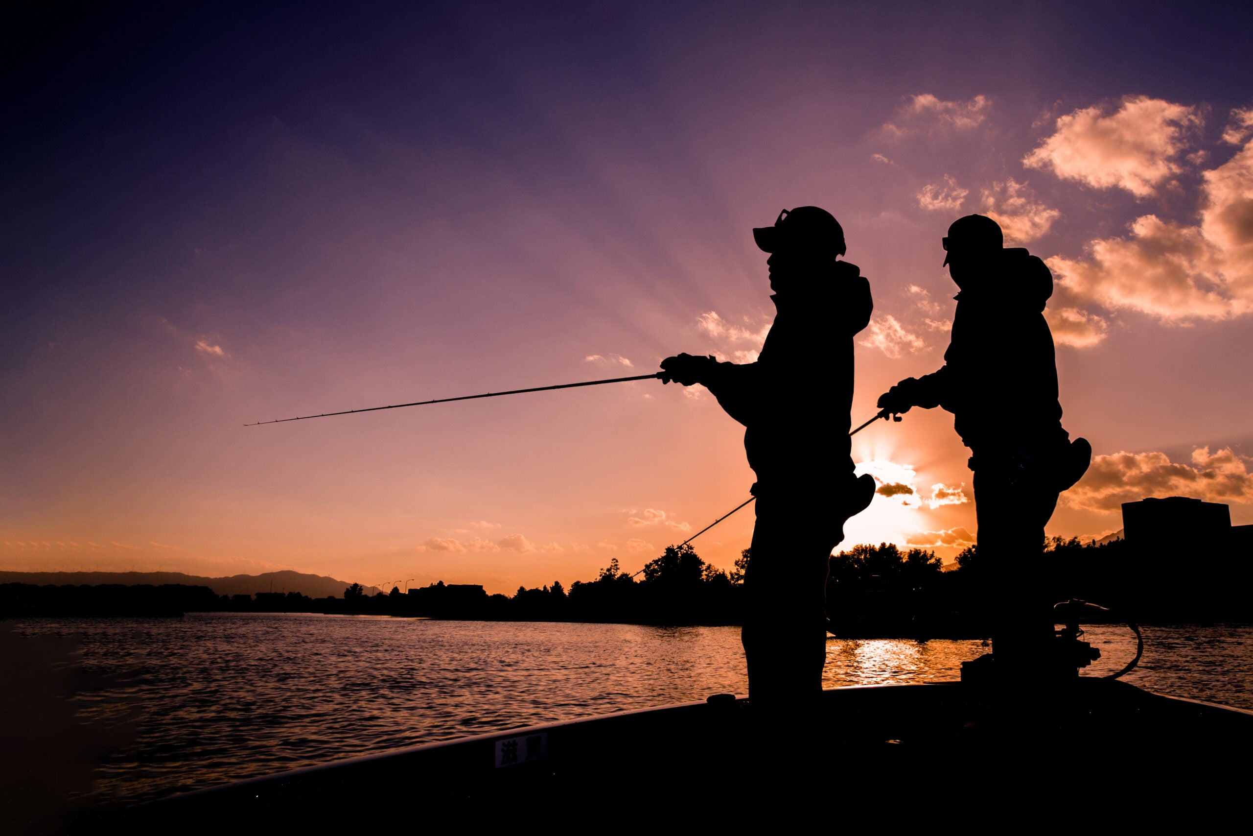summer anglers fishing for bass at dusk