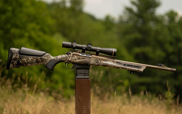 rifle balanced on its clip on an outdoor post