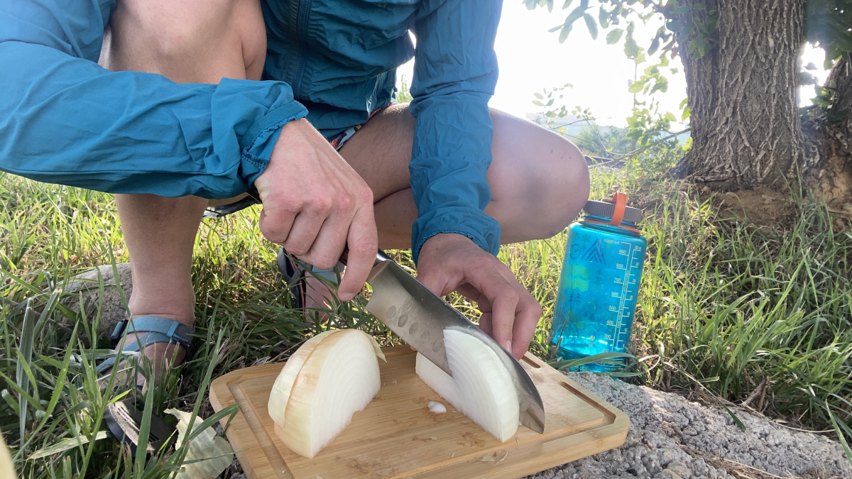 Woman chopping onions with the GSI Rakau Camping Knife