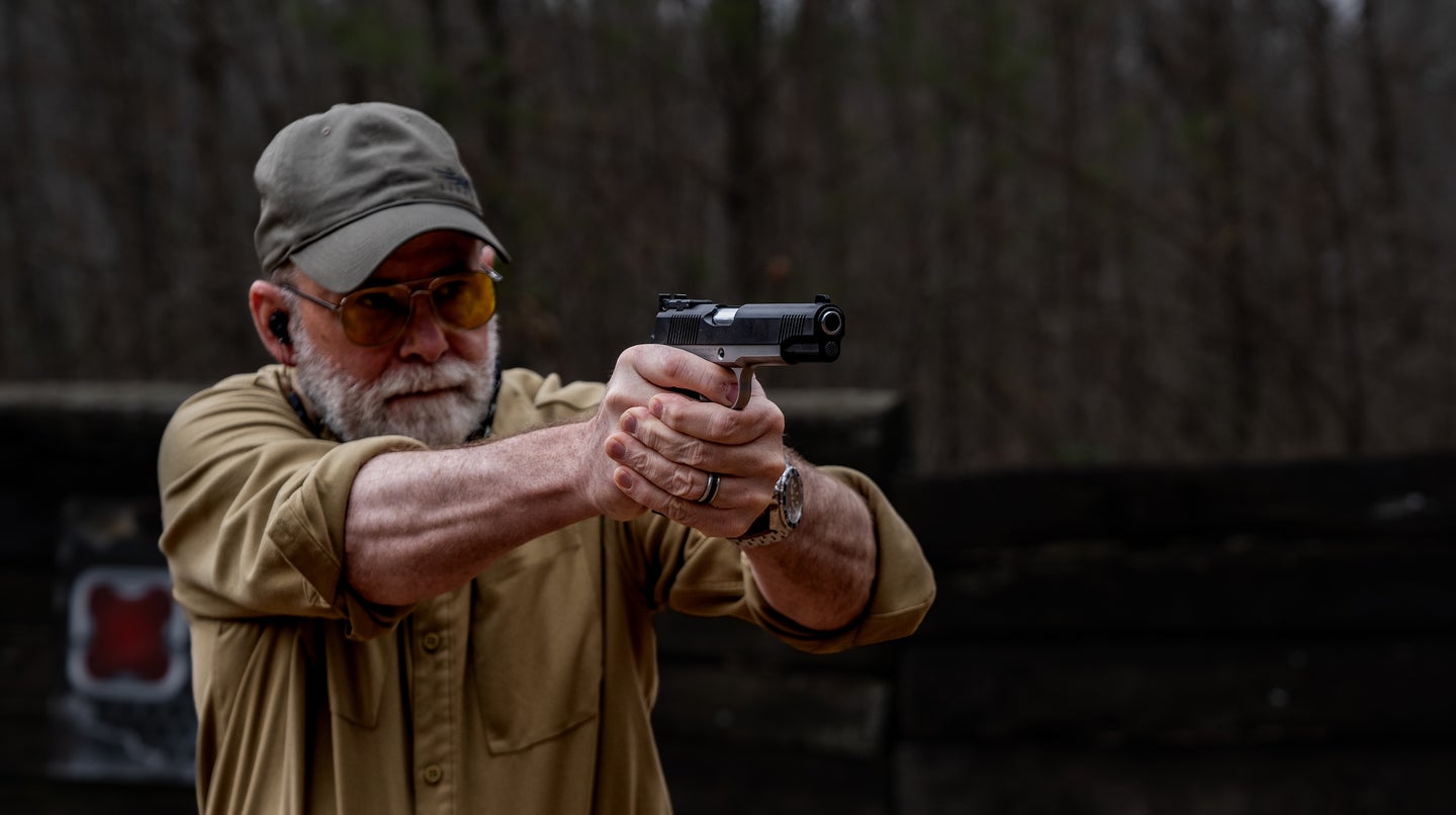 the author fires a 1911-style pistol on the range