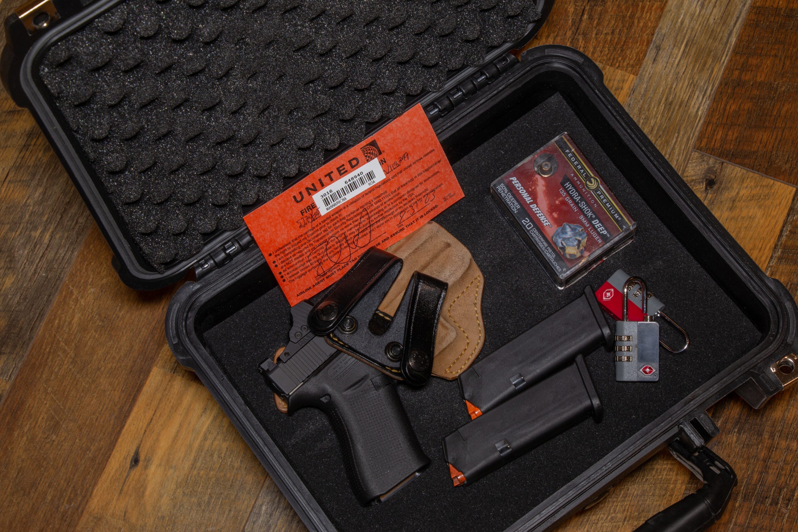 photo of a handgun in a case with TSA card, ammo, and locks, ready for flying
