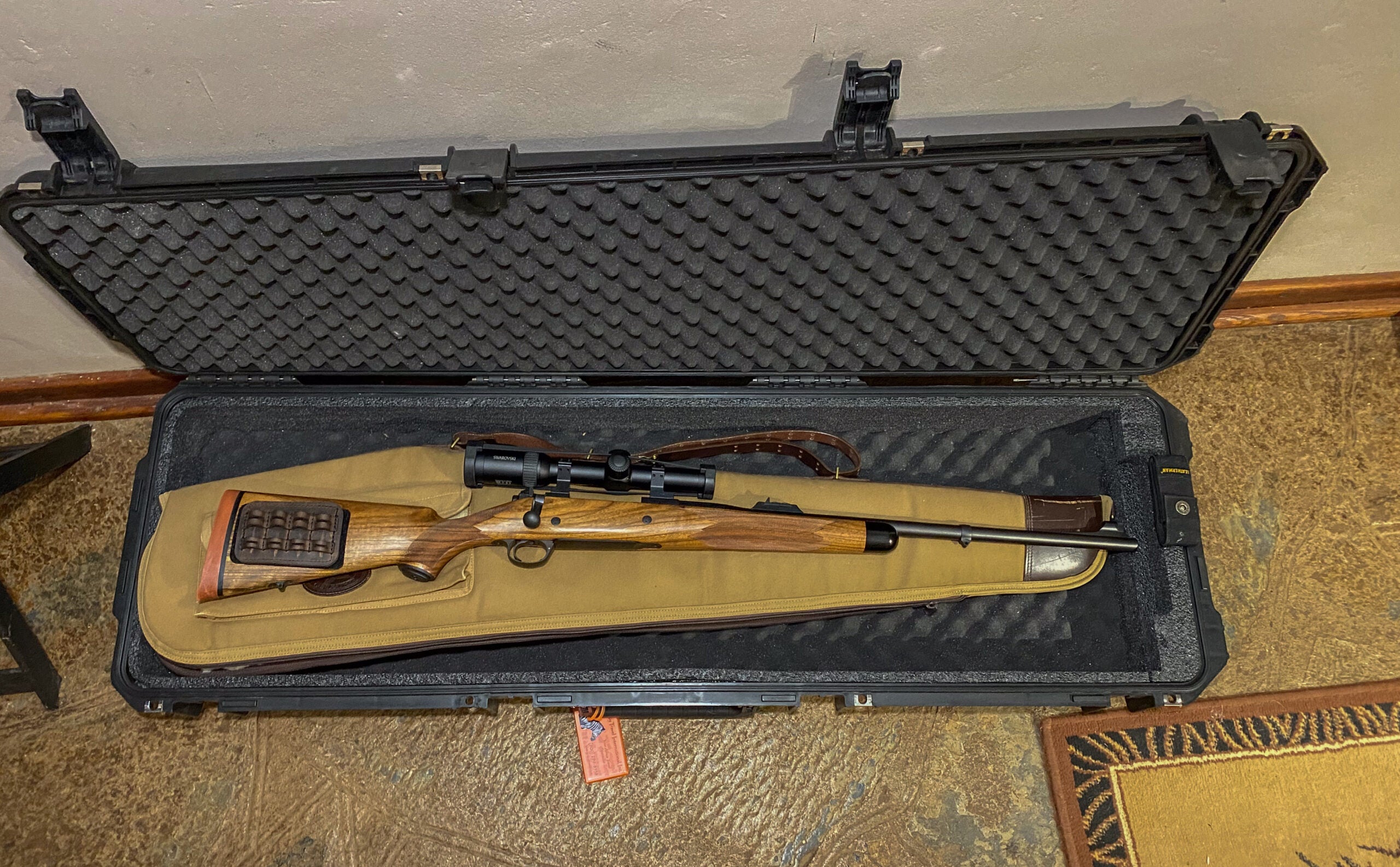 photo of a rifle in and a soft case inside a hard case