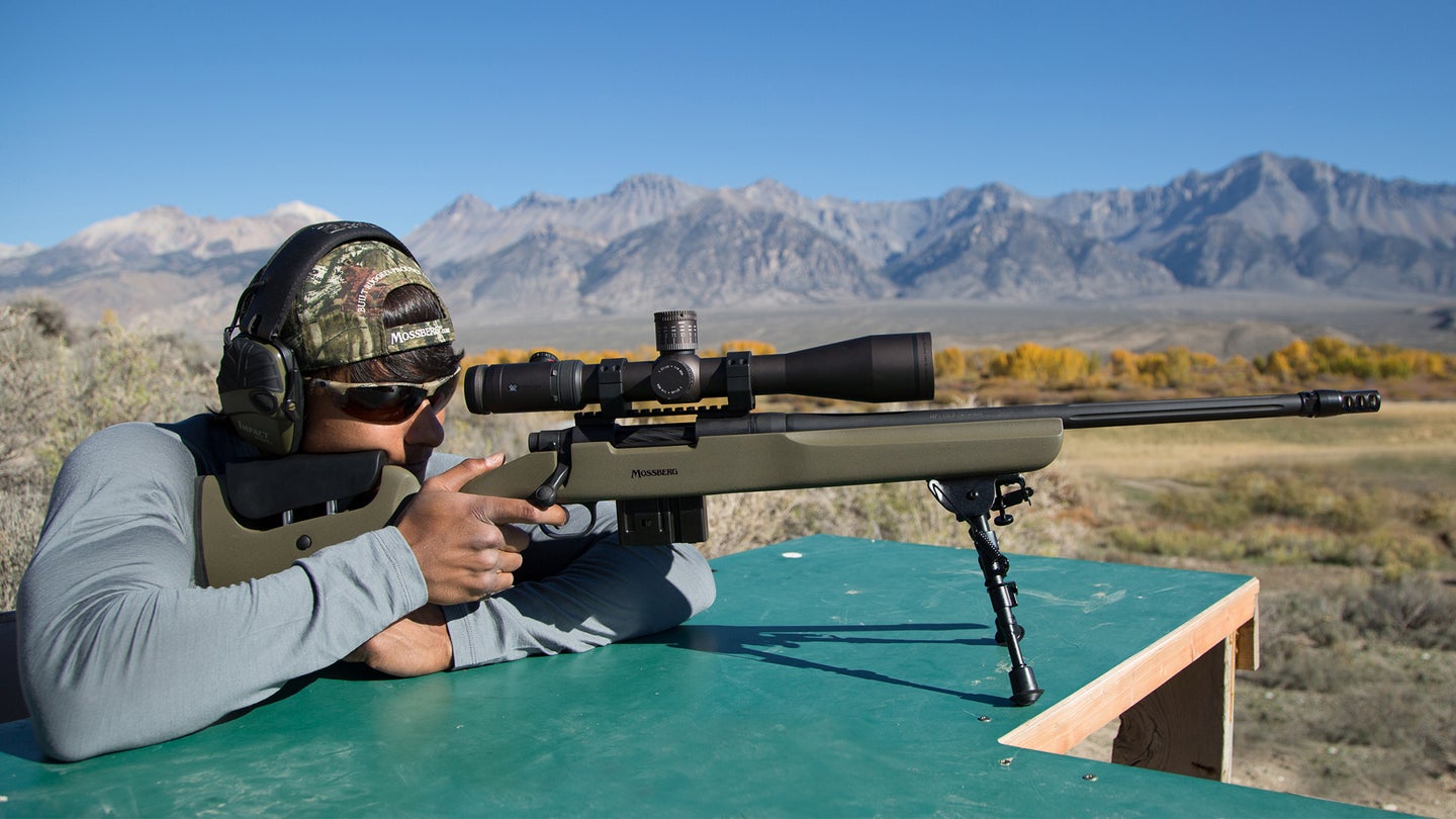 photo of a hunter shooting from a bench with a rifle that has a muzzle brake