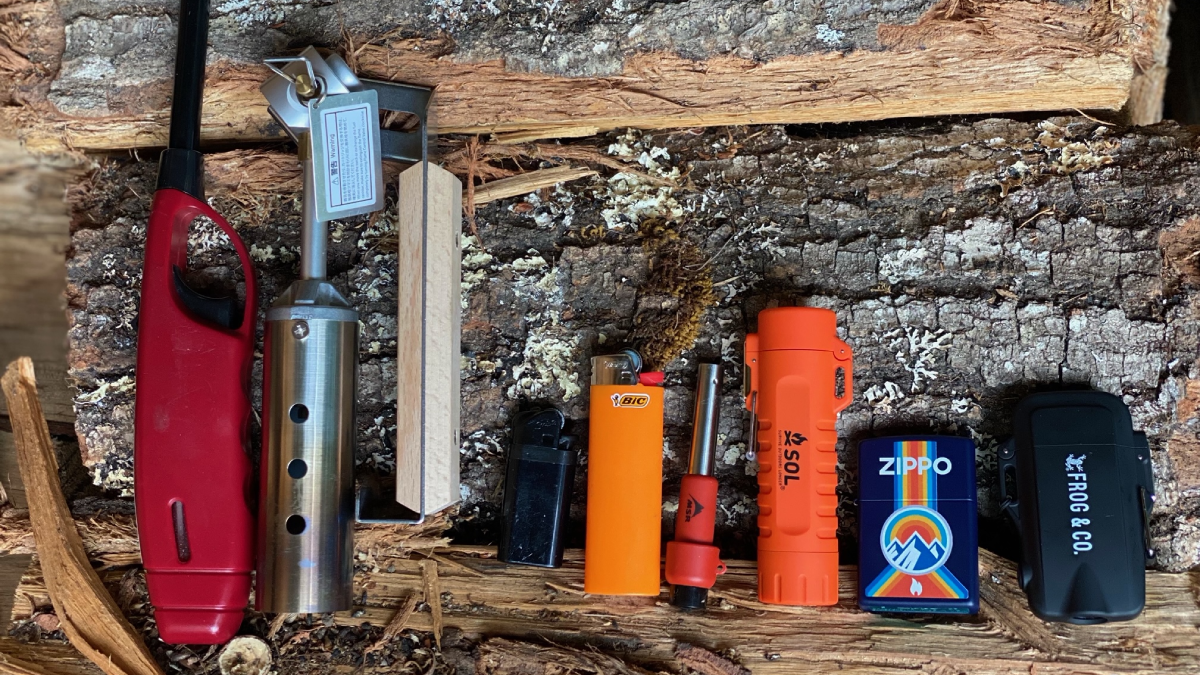 Selection of the best camping lighters sitting on a log