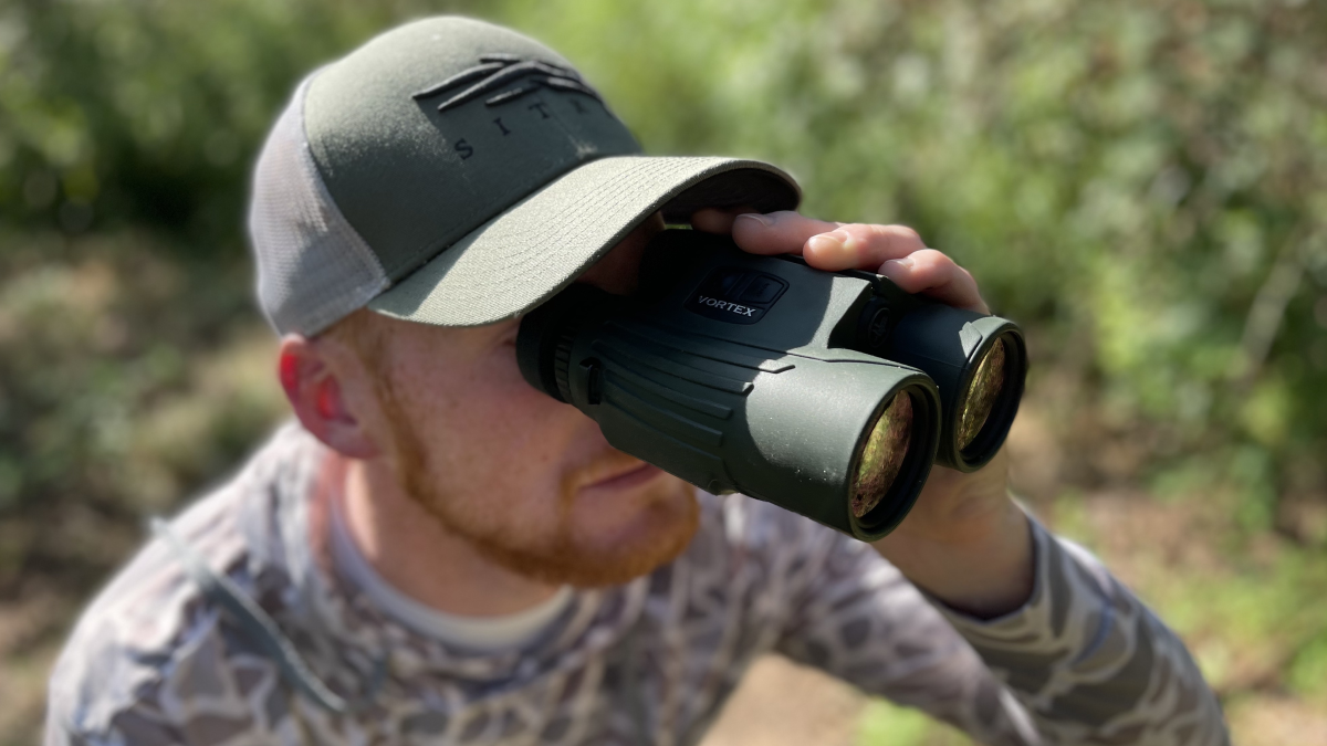 Hunter looking through Vortex Fury Rangefinder Binoculars
