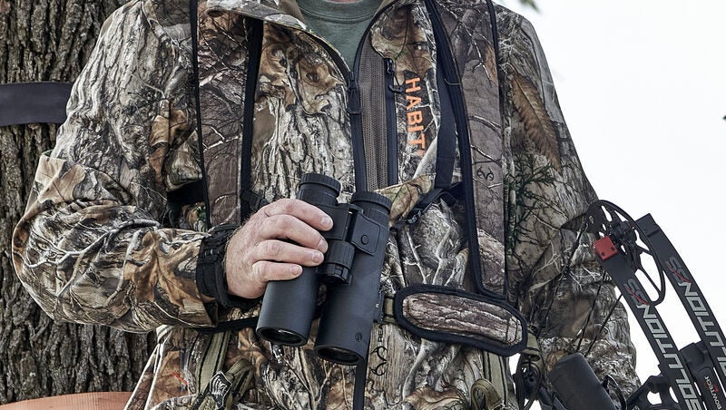 Hunter holding Bushnell Fusion X rangefinder binoculars