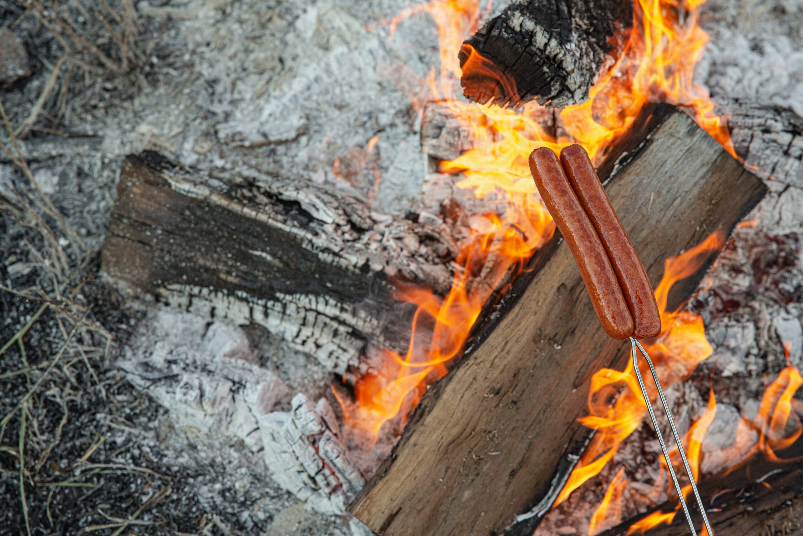 roasting hot dogs over fire are the perfect camping food idea