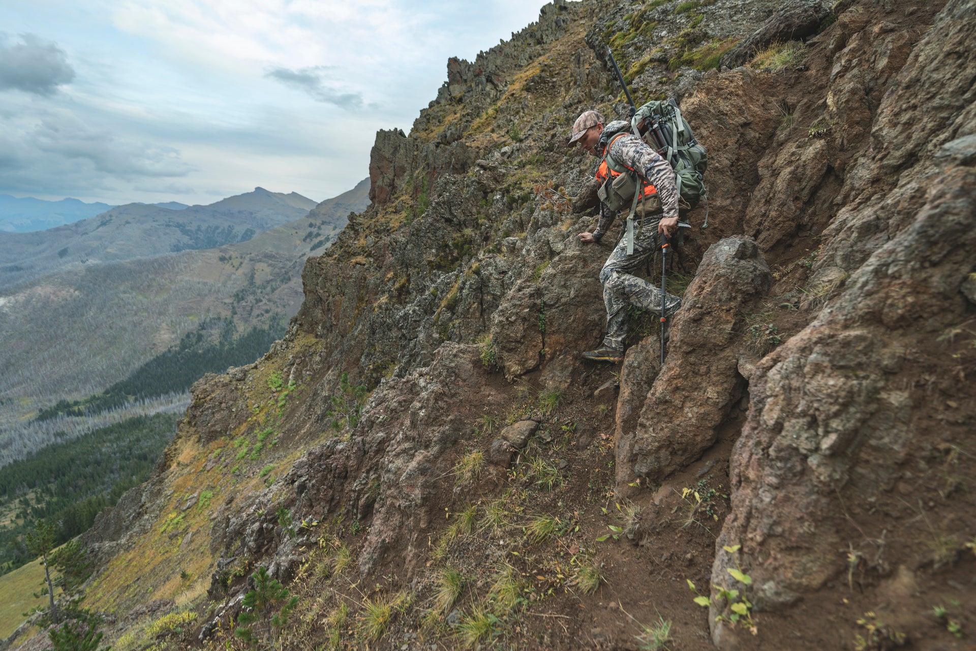 Photo of a hunter descending down a steep mountain to reflect the risks of altitude sickness