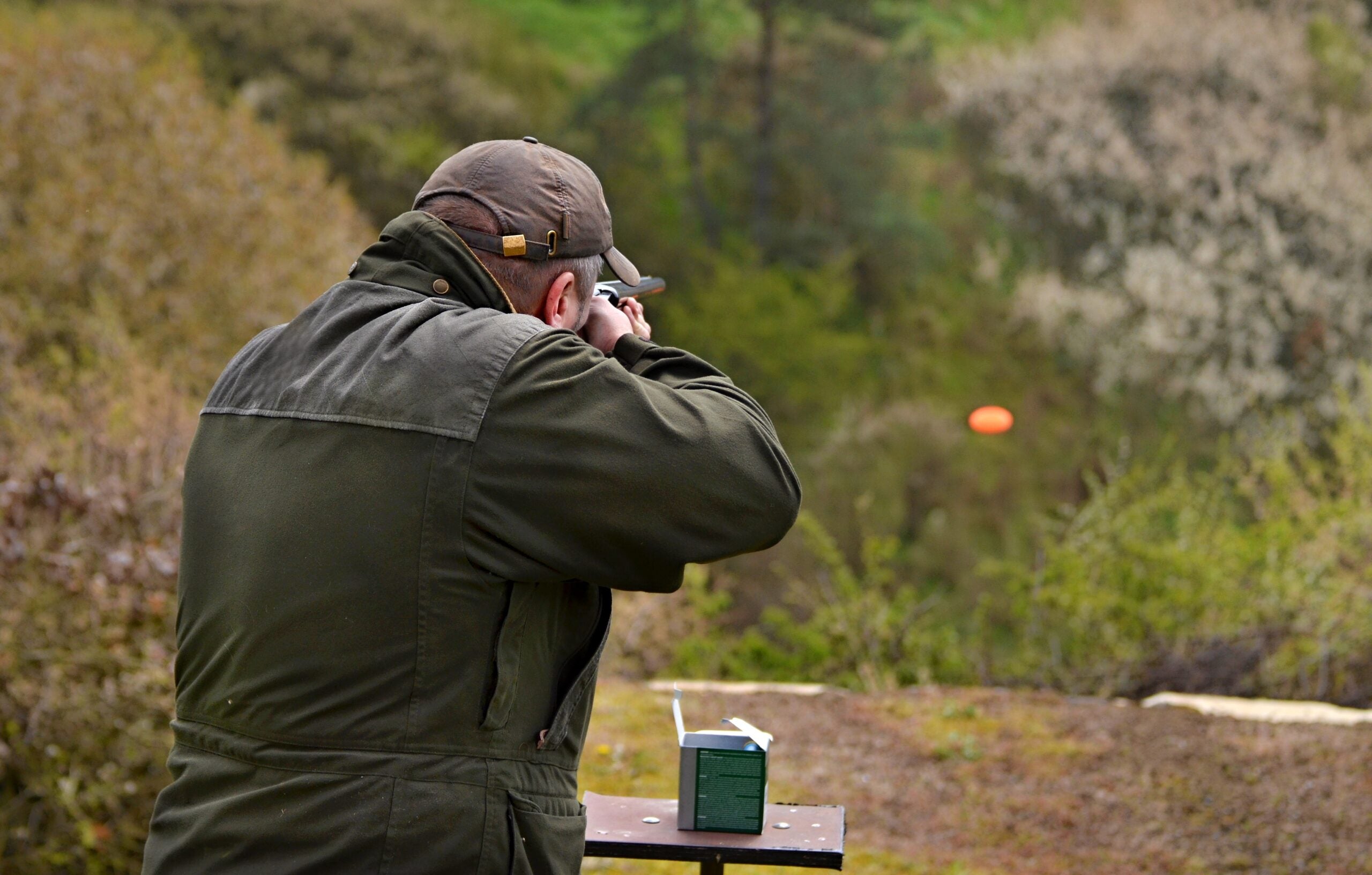 A photo of a man shooting clays at a gun range