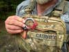hiker pulls a compass from a chestpack