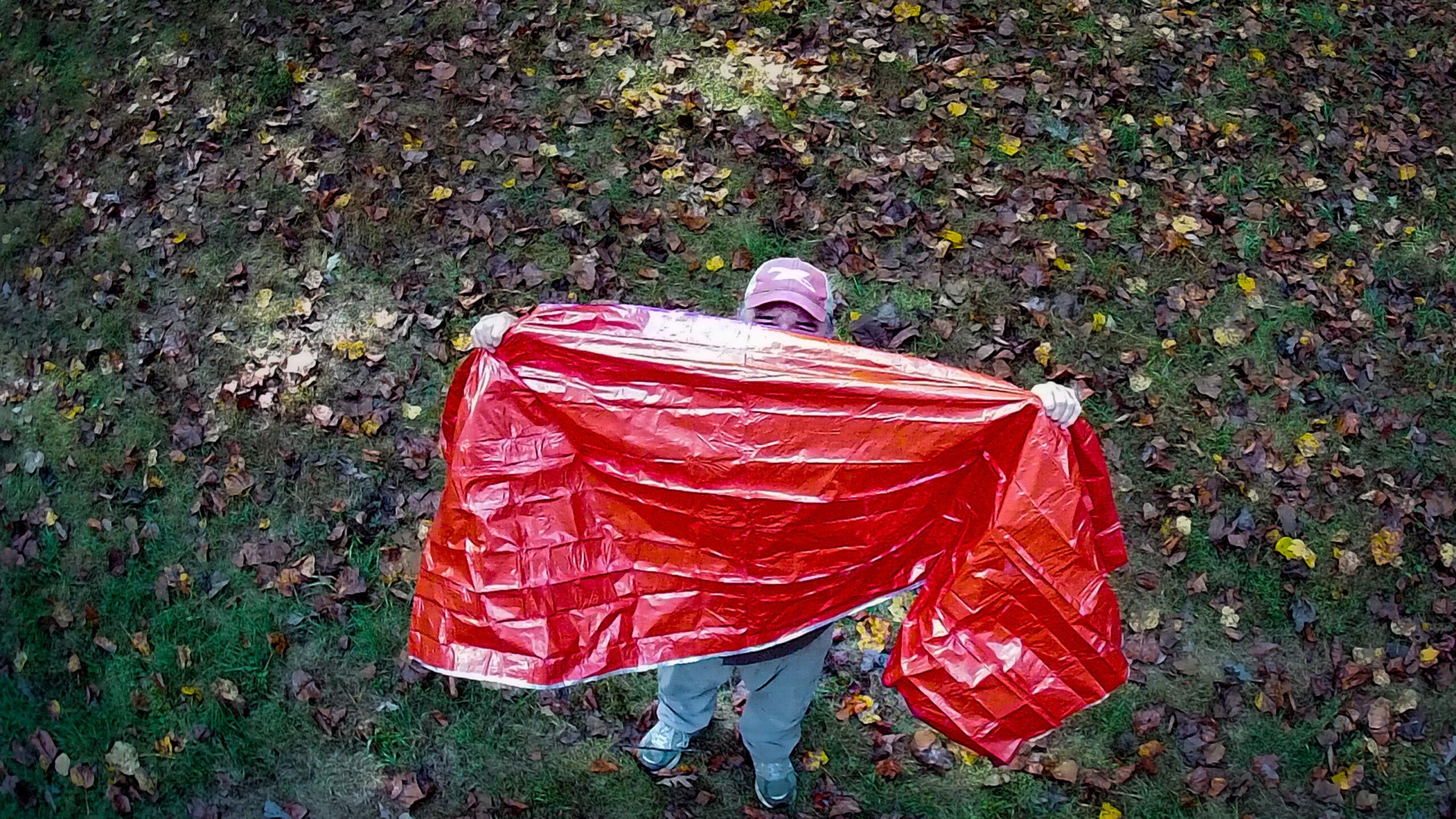 Man uses a space blanket to signal for help in the woods